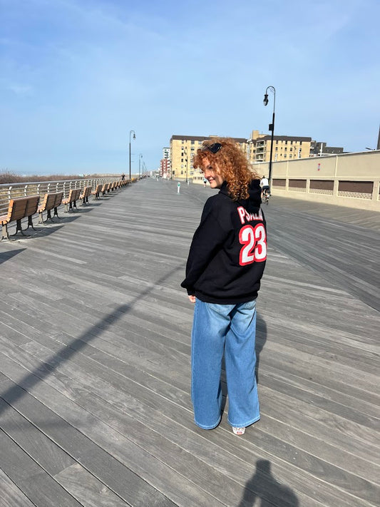 Woman wearing Psalm 23 Christian hoodie showing red and white Psalm 23 text on back on Long Beach boardwalk by Love1614