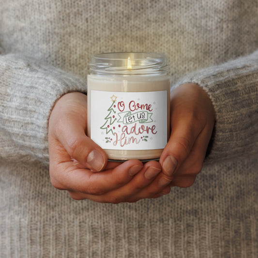 O Come Let Us Adore Him Christmas candle with black lid, lifestyle shot held in hands
