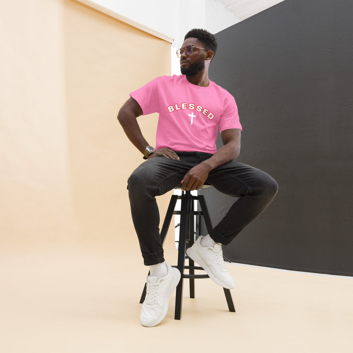 Man wearing pink Blessed Cross Christian t-shirt, seated lifestyle shot