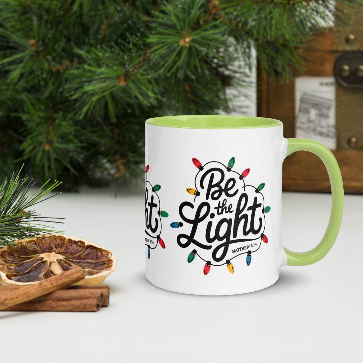 Be The Light Christmas Mug with green handle, Christmas scene lifestyle shot