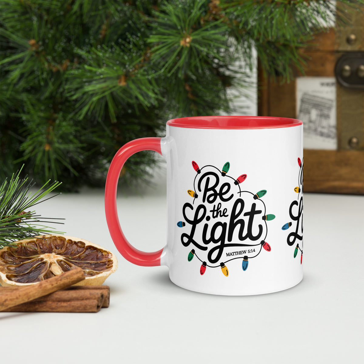 Be The Light Christmas Mug with red handle held in hand, lifestyle shot