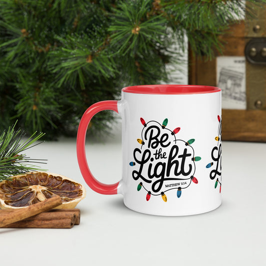 Be The Light Christmas Mug with red handle held in hand, lifestyle shot